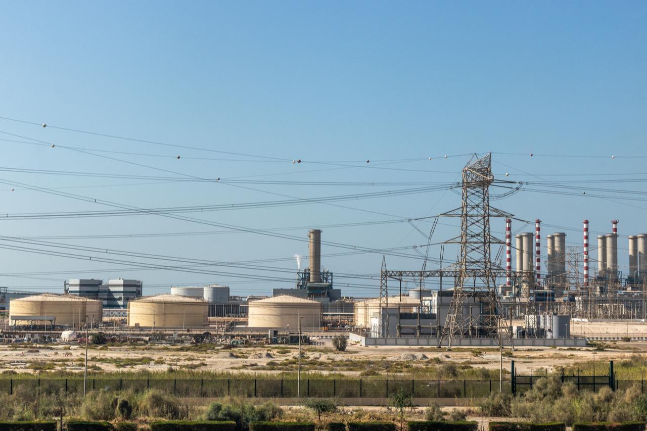 Oil storage tanks and power infrastructure at an industrial energy facility in Dubai, the United Arab Emirates. (Adobe Stock Photo)