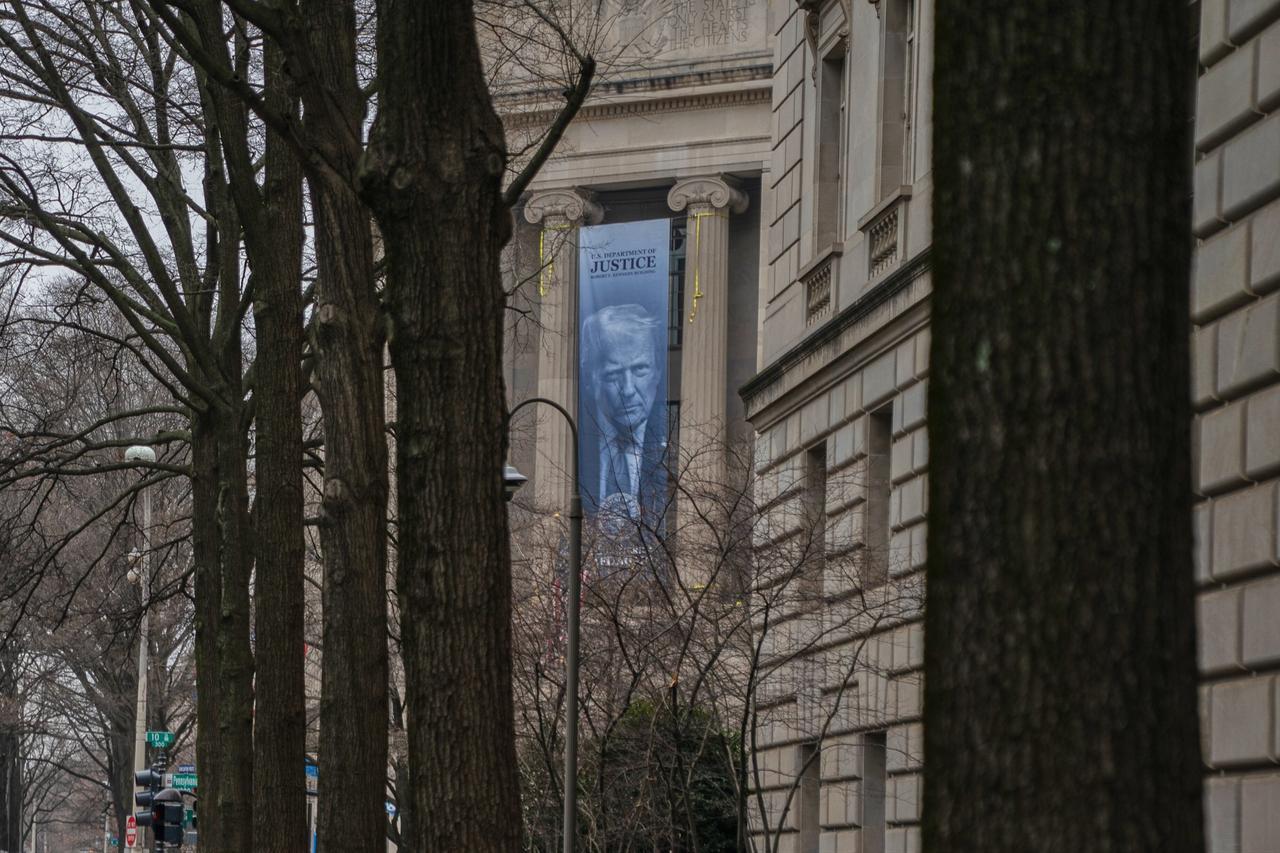 Large banner displaying Donald Trump’s portrait on the exterior of the U.S. Department of Justice headquarters, Washington, United States, February 19, 2026. (Photo via Facebook / @News4JAX)