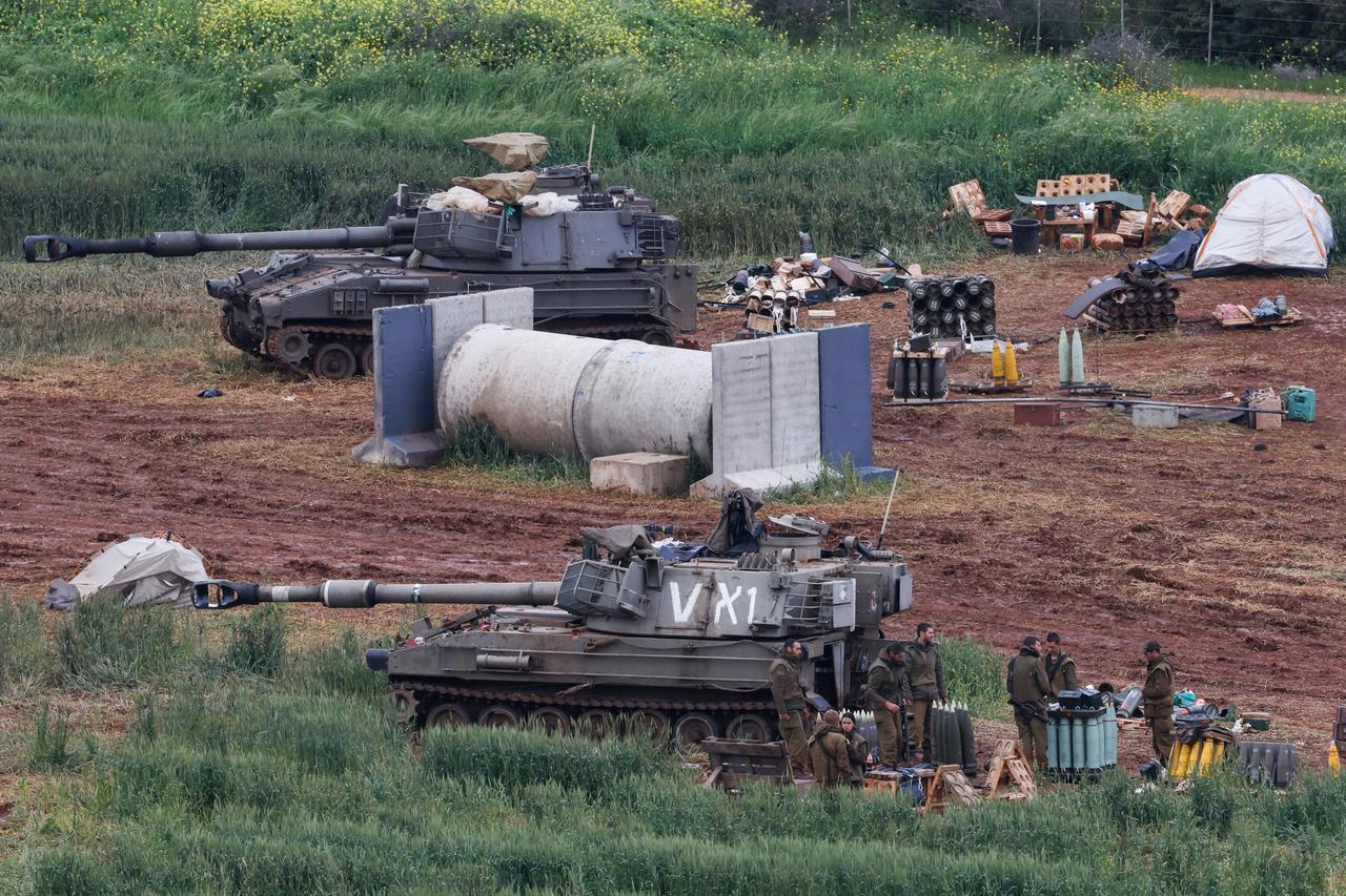 Israeli army soldiers stand next to a self-propelled Howitzer artillery gun positioned in the upper Galilee in northern Israel near the border with southern Lebanon, March 29, 2026. (AFP Photo)
