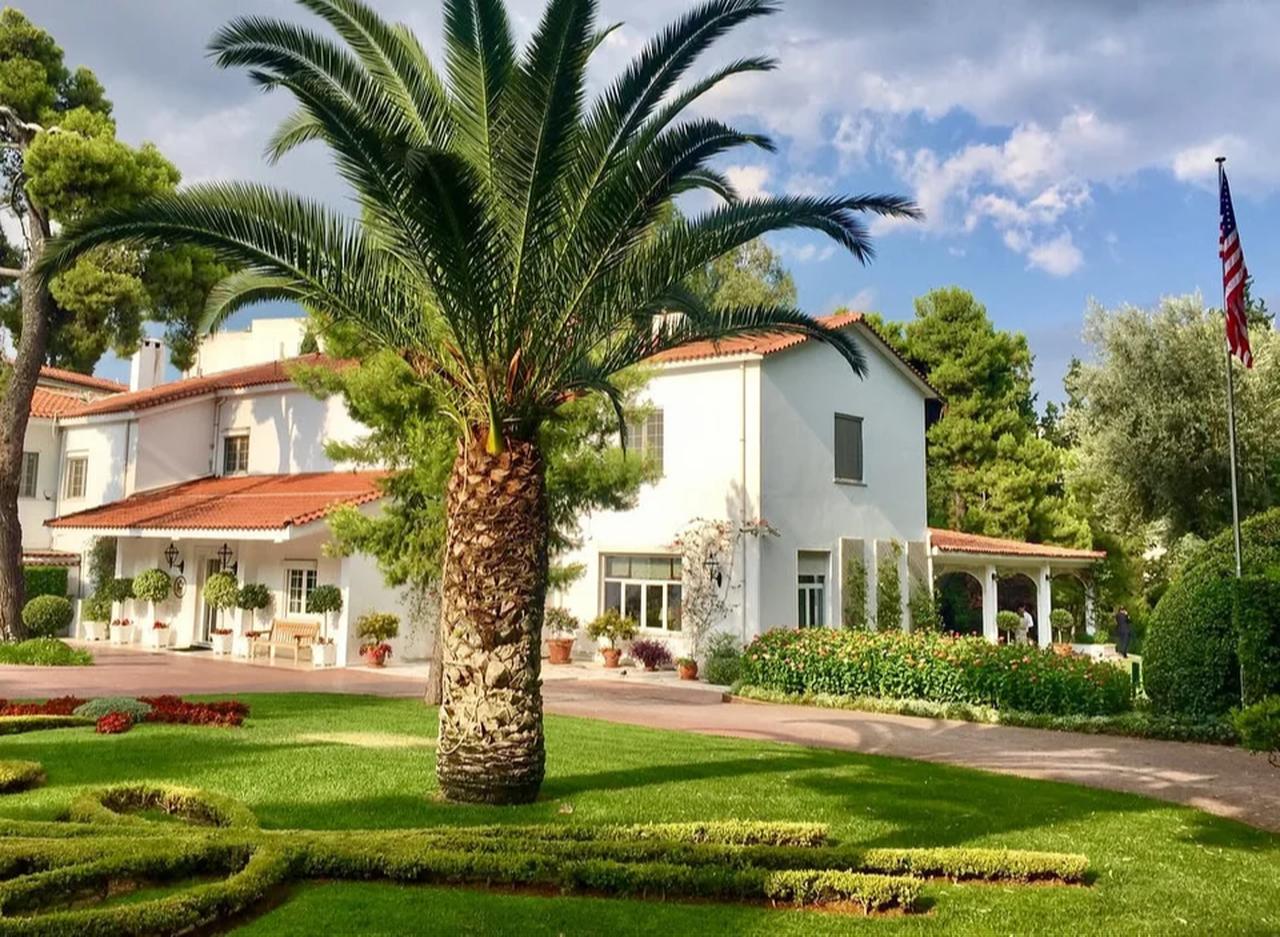 Exterior view of the U.S. ambassador’s residence in Athens, Greece, surrounded by landscaped gardens. (Photo via iefimerida)