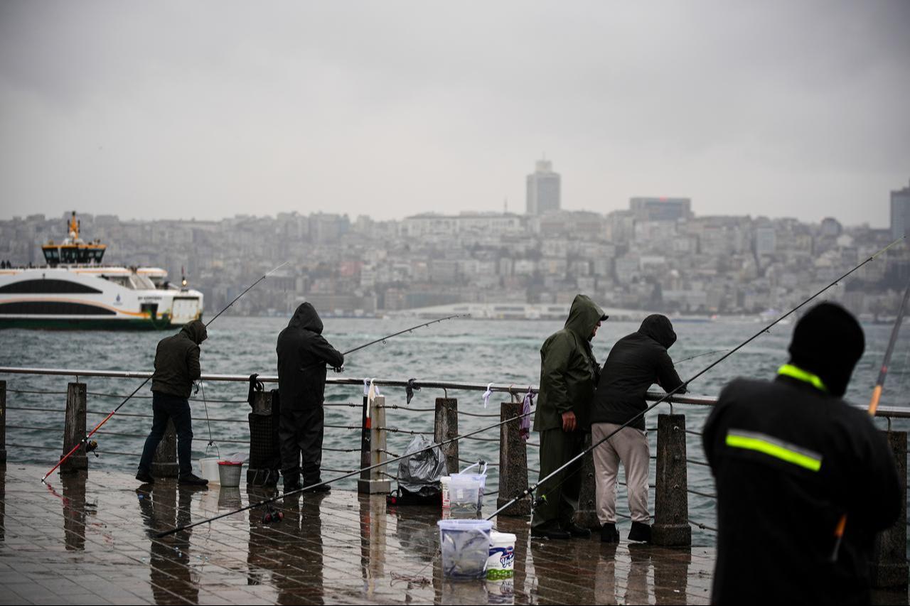 People are seen fishing during rainfall at the Uskudar district of Istanbul, Türkiye, on March 29, 2026. (AA Photo)