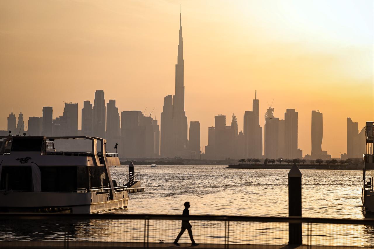 A man walks along Dubai's Creek Harbour, with the Burj Khalifa visible in the background, on April 3, 2026. (AFP Photo)