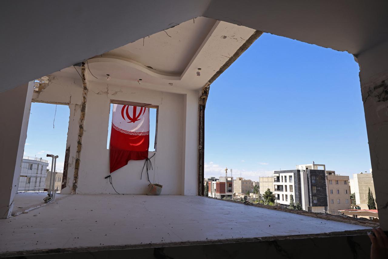 An Iranian flag is seen on a residential building that was damaged by recent strikes at Vahdat town in Karaj, southwest of Tehran on April 3, 2026. (AFP Photo)