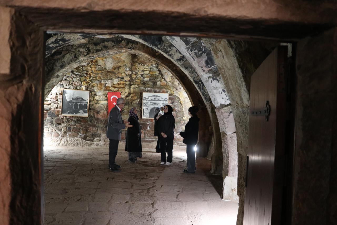 Visitors listen as Ahmet Bekdas presents details about the structure and history of Mimar Sinan’s birthplace in Kayseri, Türkiye, April 5, 2026. (AA Photo)
