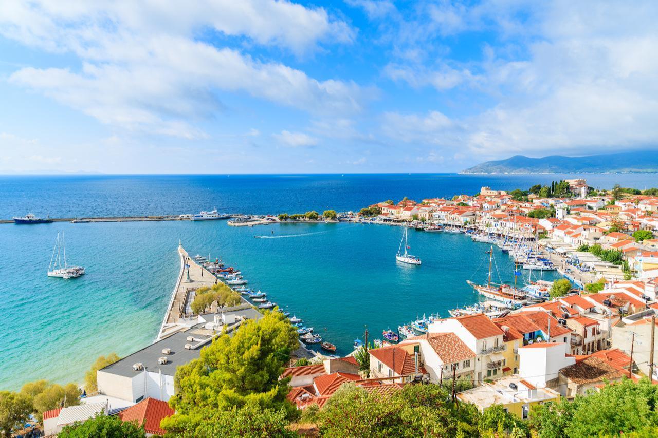 Pythagorion port is seen with colorful houses and the Aegean Sea on Samos island, Greece. (Adobe Stock)
