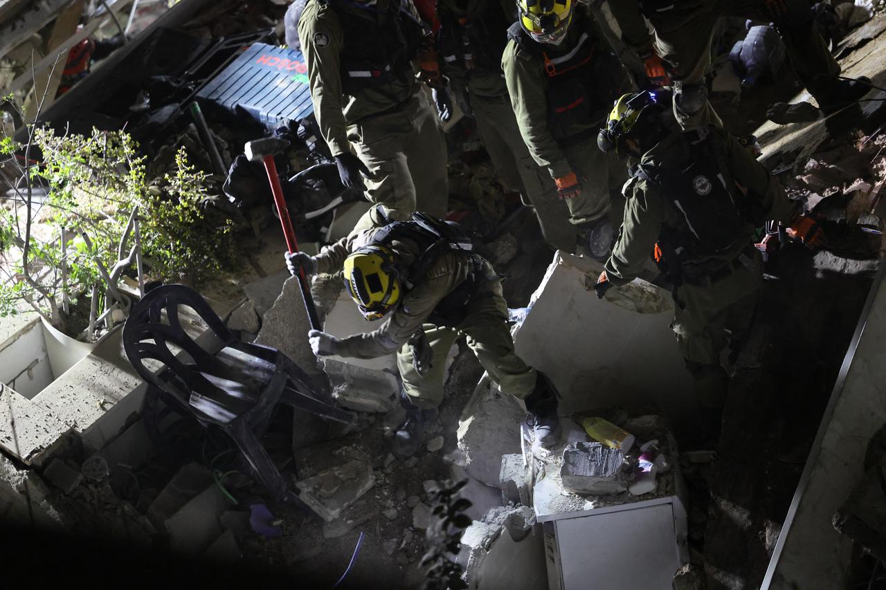 Israeli search and rescue personnel work at the site of a residential building destroyed in an Iranian strike in the northern city of Haifa, April 5, 2026. (AFP Photo)