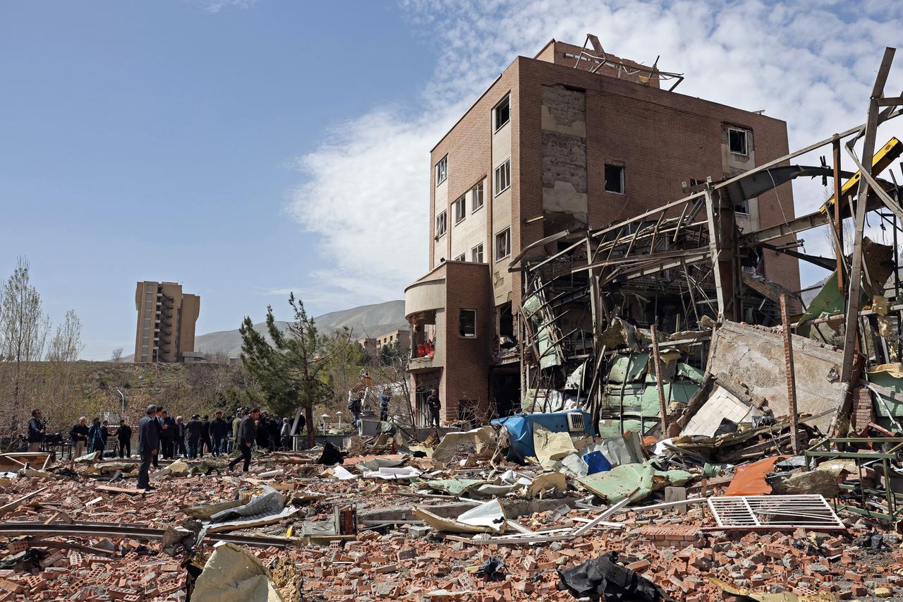 Officials and media representatives gather around the damaged building of the Shahid Beheshti University following a strike, in Tehran, Iran on April 4, 2026. (AFP Photo)