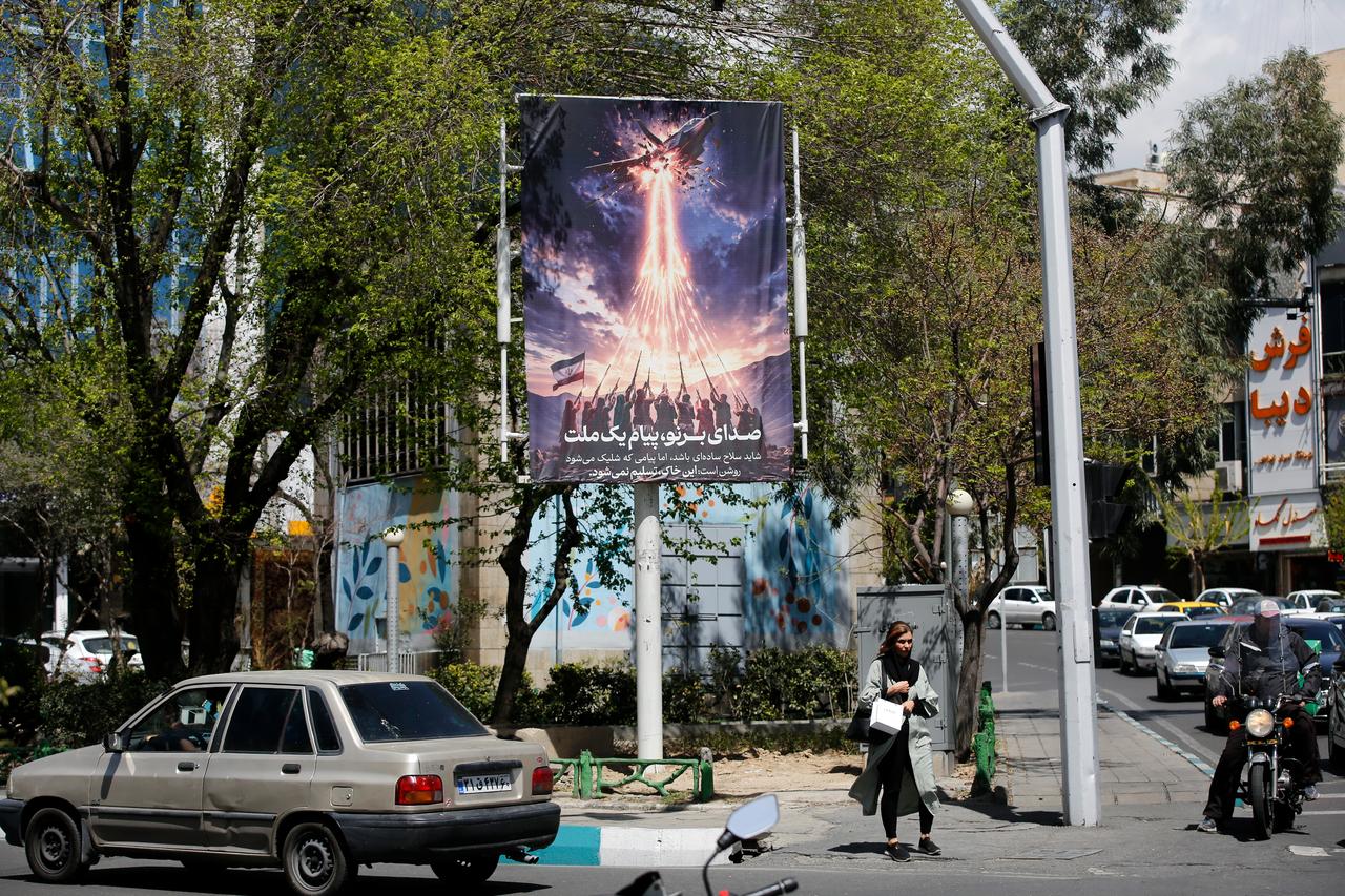 A poster depicting the downing of a US aircraft with the message “This land will not surrender” is displayed on a street in Tehran, Iran on April 5, 2026. (AA Photo)