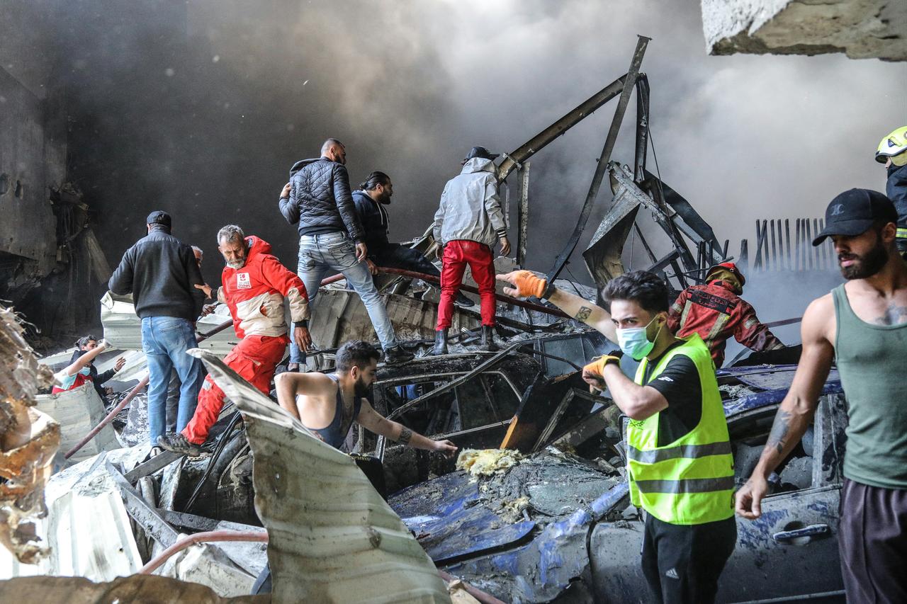 First responders and residents stand amid rubble at the site of an Israeli airstrike in Beirut's Corniche al-Mazraa neighborhood on April 8, 2026. (AFP Photo)