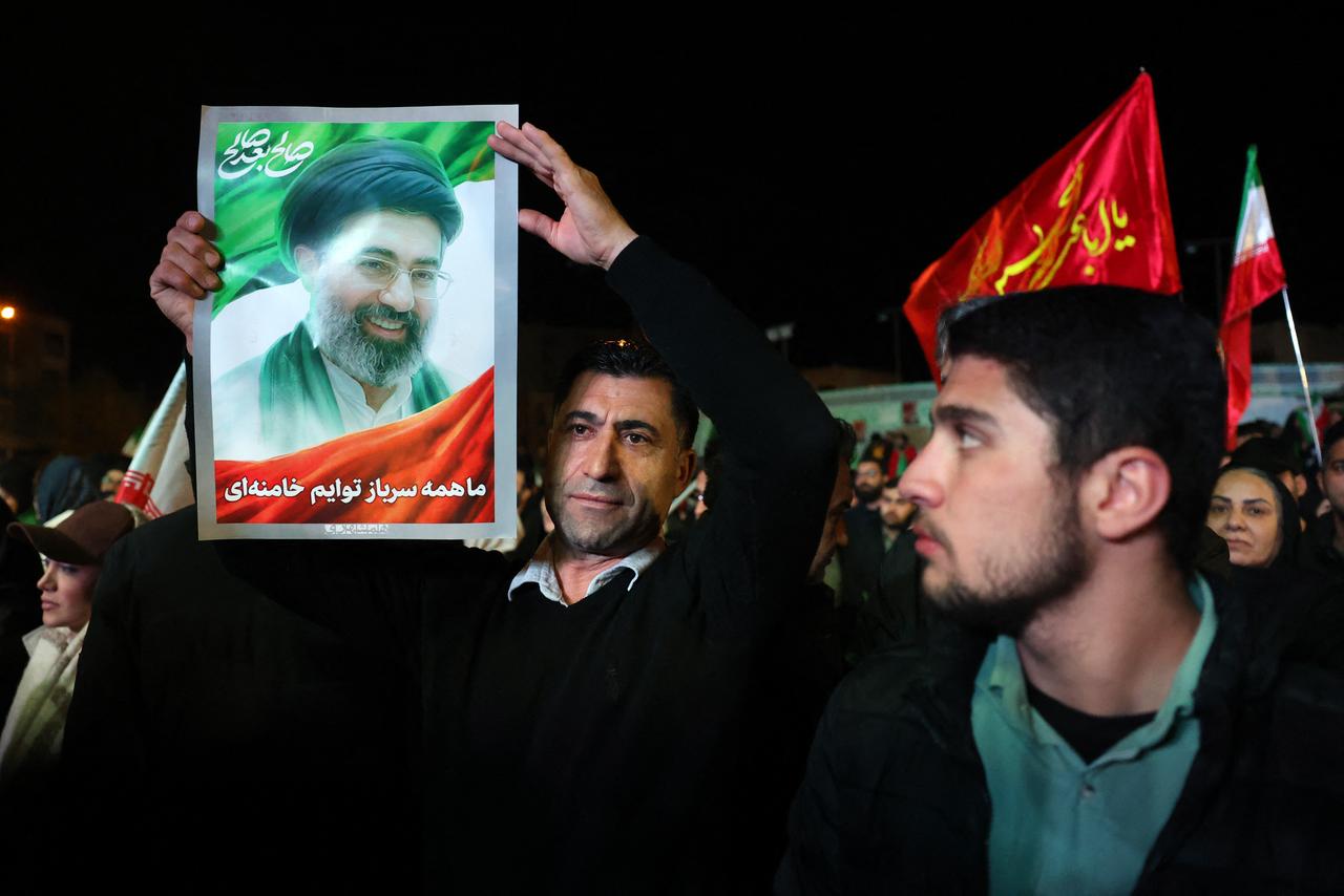 An Iranian man holds up picture of Iranian supreme leader Mojataba Khamenei as others react to a ceasefire announcement at the Enqelab square, in Tehran, April 8 2026. (AFP Photo)
