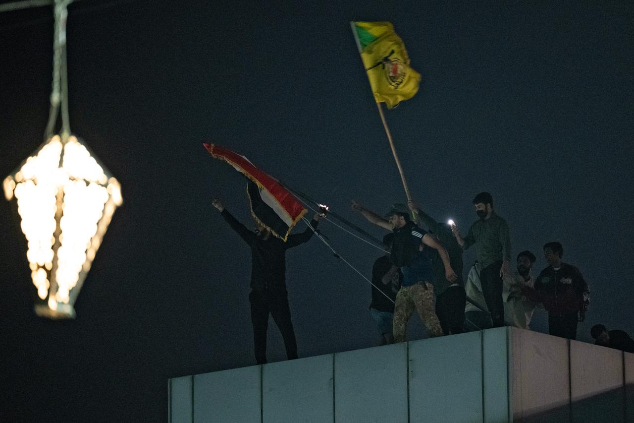 Iraqis stand on a rooftop during a protest outside the Kuwaiti Consulate, following a strike that killed three people in a nearby town, in the southern Iraqi city of Basra on April 7, 2026. (AFP Photo)
