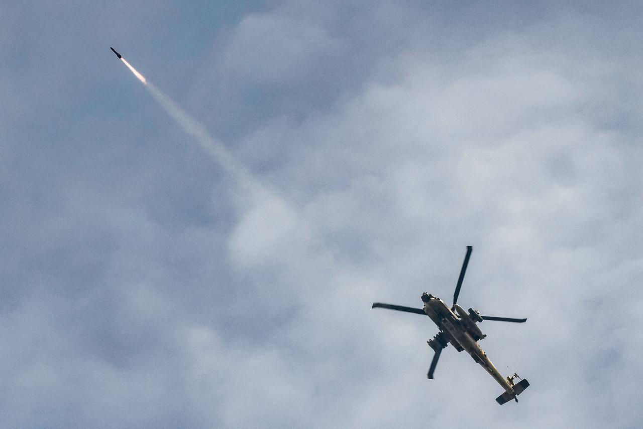 An Israeli Air Force AH-64 Apache attack helicopter fires rockets while flying along the border between northern Israel and southern Lebanon on March 18, 2026. (AFP Photo)