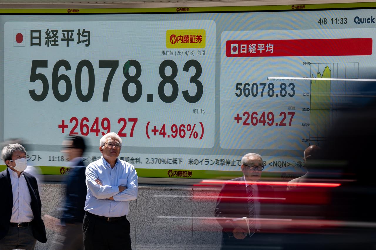 People wait in front of an electronic quotation board displaying the Nikkei 225 stock prices on the Tokyo Stock Exchange in Tokyo, April 8, 2026. (AFP Photo)