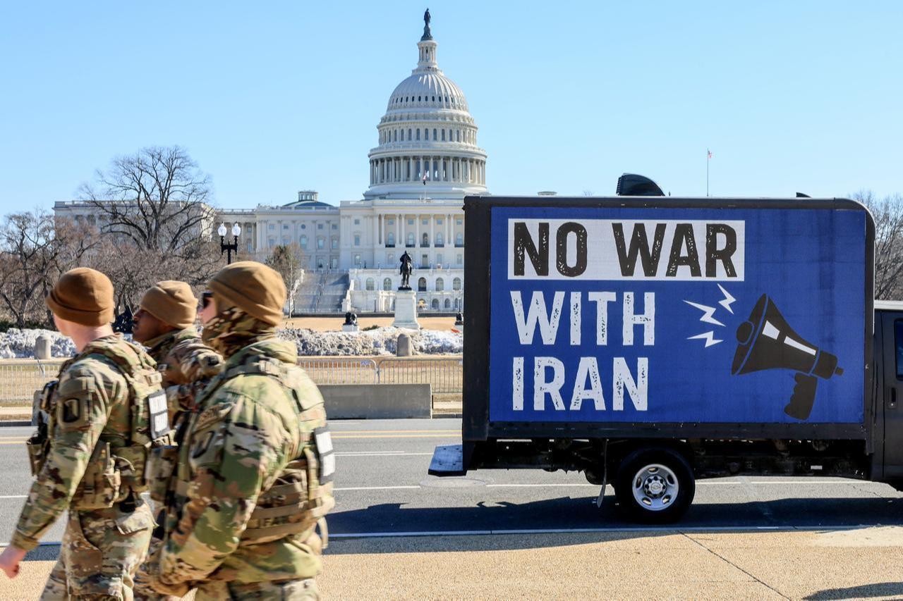 National Guard members patrol near the U.S. Capitol as a truck displays a “No War With Iran” message. (Photo via Win without War)