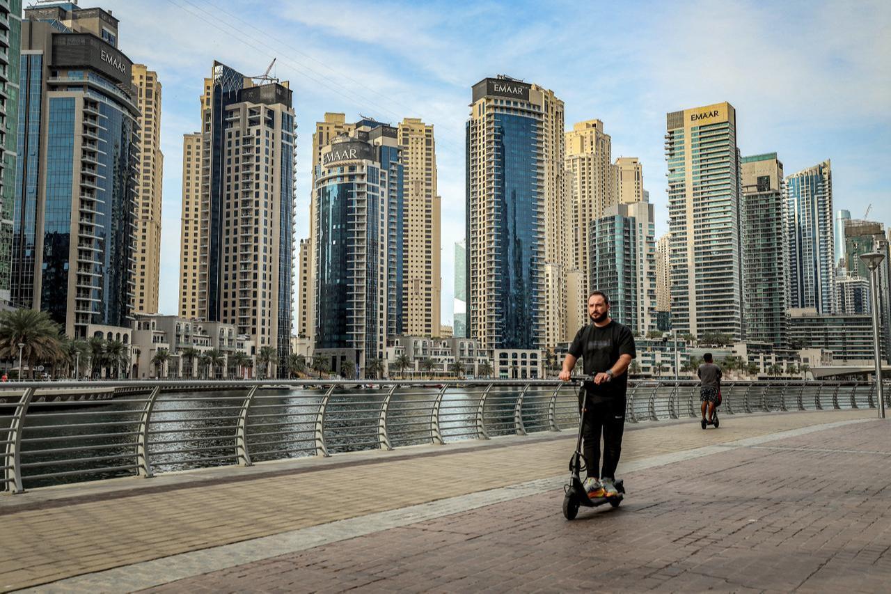 A man rides a scooter at the Dubai Marina in Dubai, March 11, 2026. (AFP Photo)