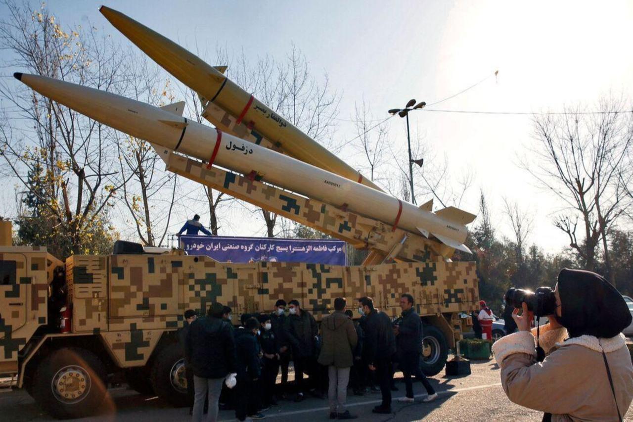 An Iranian woman takes a picture of Zolfaghar-Basir and Dezful missiles displayed at the Mosallah mosque, January 7, 2022. (AFP Photo)