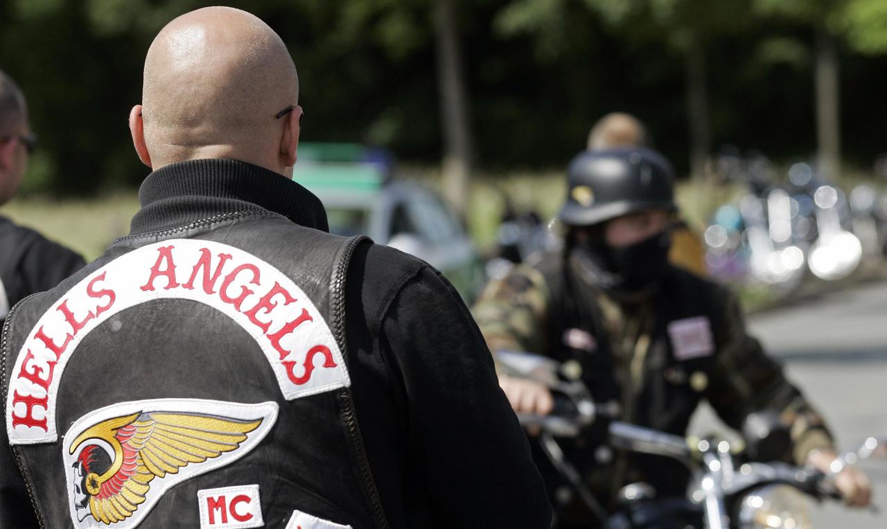 A man wearing a Hells Angels jacket looks on in 2007 as other motorcyclists arrive at a shop in Ibbenbüren, Germany. (AFP Photo)