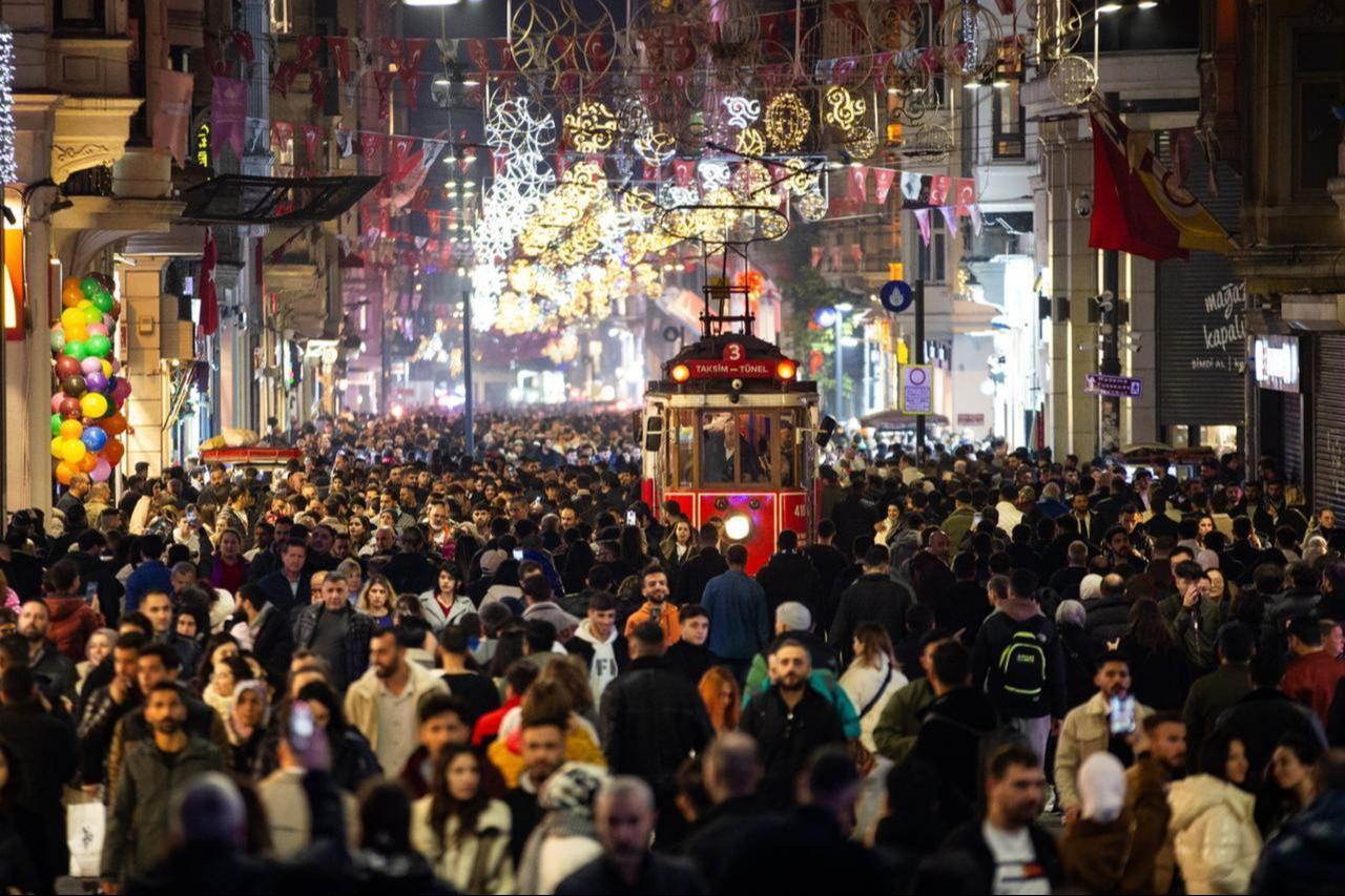 A bustling evening on Istiklal Avenue in Istanbul, as crowds enjoy the lively atmosphere and iconic red tram during the winter season, Türkiye, Dec. 31, 2023. (AA Photo)