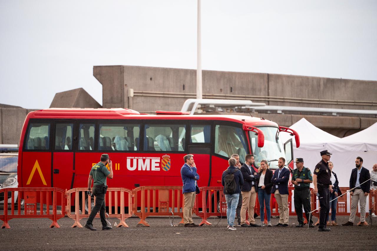 Authorities stand by a military bus which will be used to transfer evacuees from the Dutch flagged hantavirus-stricken cruise ship MV Hondius at the industrial port of Granadilla de Abona on the island of Tenerife in Spain's Canary Islands on May 10, 2026. (AFP Photo)