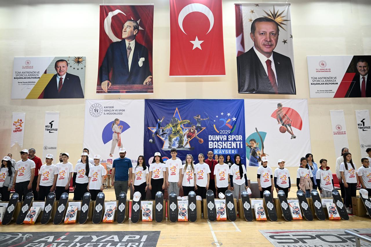 Students stand with skateboards during the launch event of the Flying Skateboard Project organized by the Türkiye Skateboarding Federation at Atatürk Sports Hall in Kayseri, where 300 students were gifted skateboards, May 7, 2026. (AA Photo)