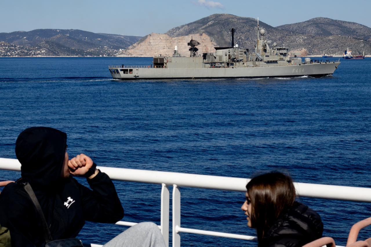 Passengers onboard the Pereus Agena ship look on as the Greek warship "KANARIS" sails the Argosaronic Gulf outside Athens on May 4, 2026. (AFP Photo)