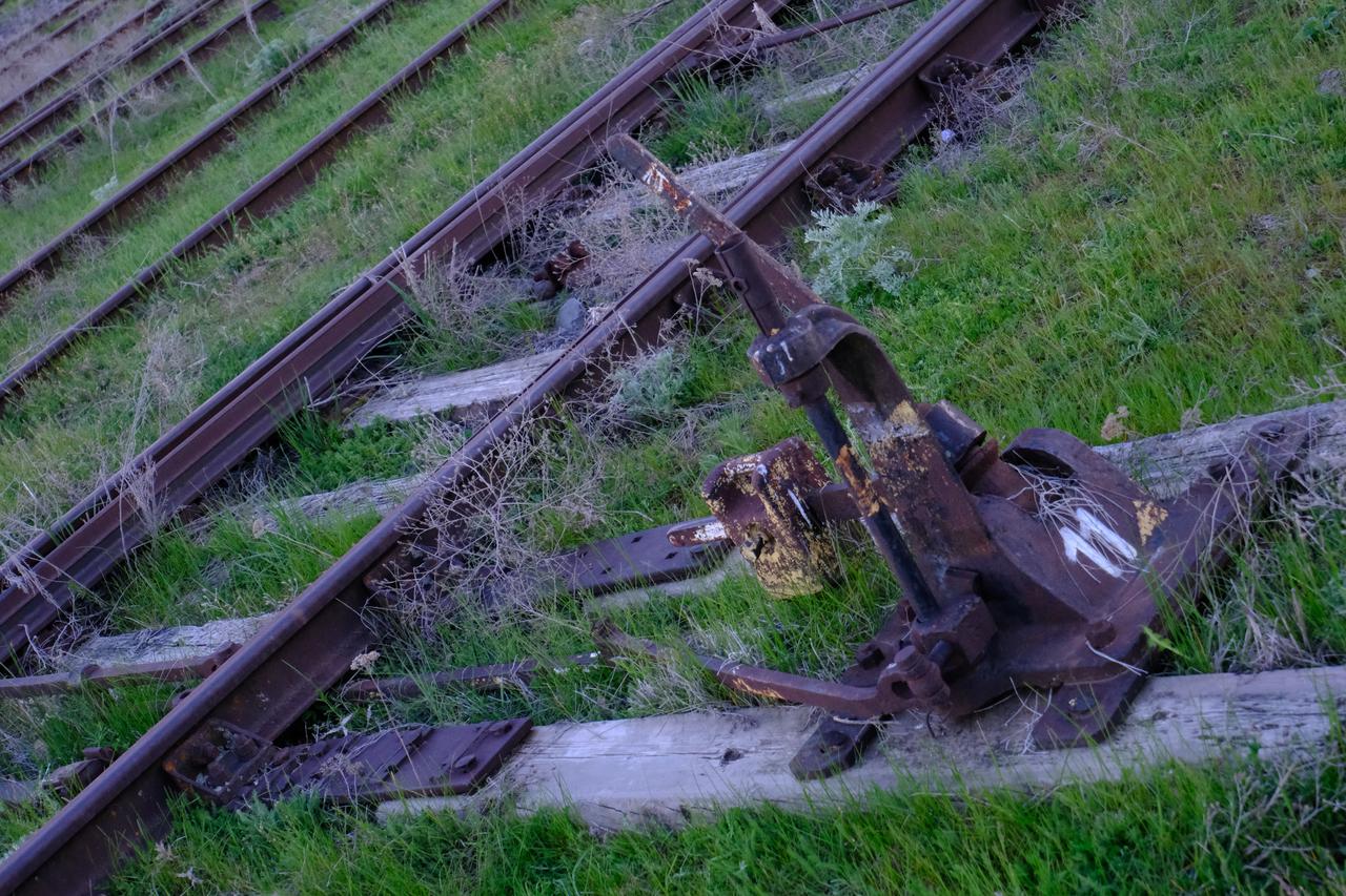 A rusted manual switch lever, marked number 11, sits frozen among overgrown sleepers at Akhuryan Station on the Armenian side of the Türkiye-Armenia border on May 8, 2026. (Yagiz Efe Parmaksiz / Türkiye Today)