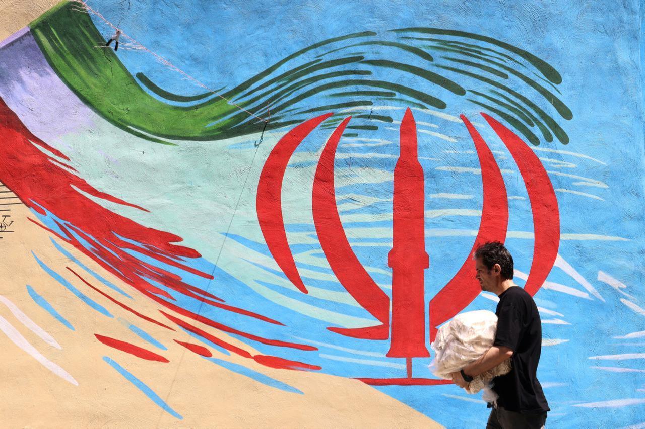 An Iranian man walks past an anti-US and anti-Israel mural painted on a wall in the capital Tehran on May 10, 2026. (AFP Photo)
