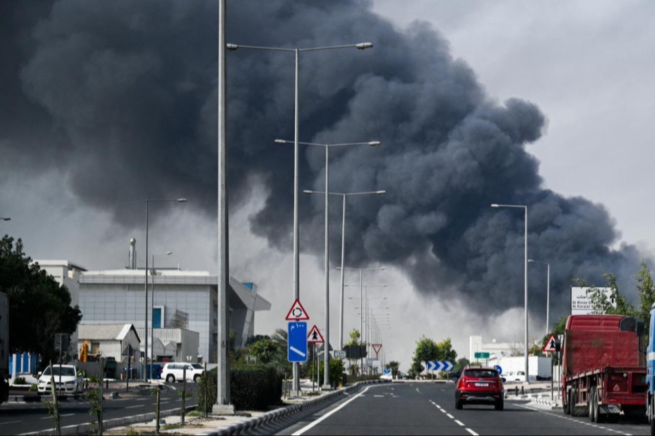 Motorists drive past a plume of smoke rising from a reported Iranian strike in the industrial district of Doha, Qatar on March 1, 2026. (AFP Photo)