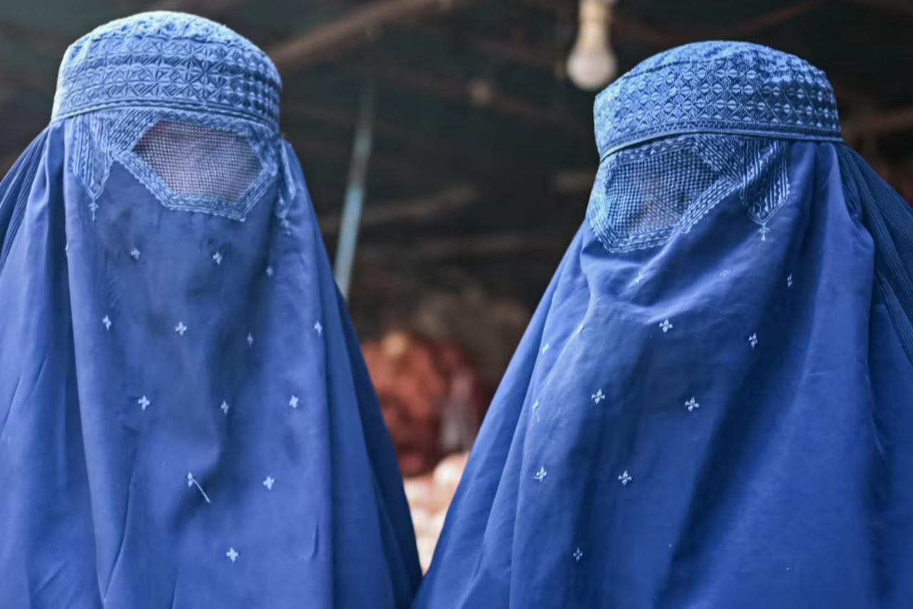 Afghan women wearing burqas walk through a market in Kabul, Afghanistan, Dec. 20, 2021. (AFP Photo)