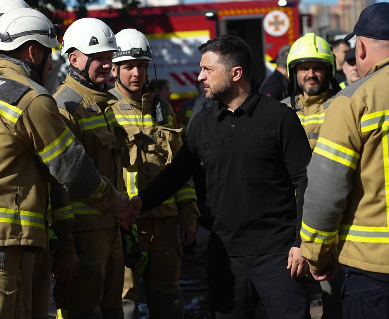 Ukraine's President Volodymyr Zelensky (C) meets with Ukrainian rescuers at the site of an air attack in Kyiv, May 15, 2026. (AFP Photo)