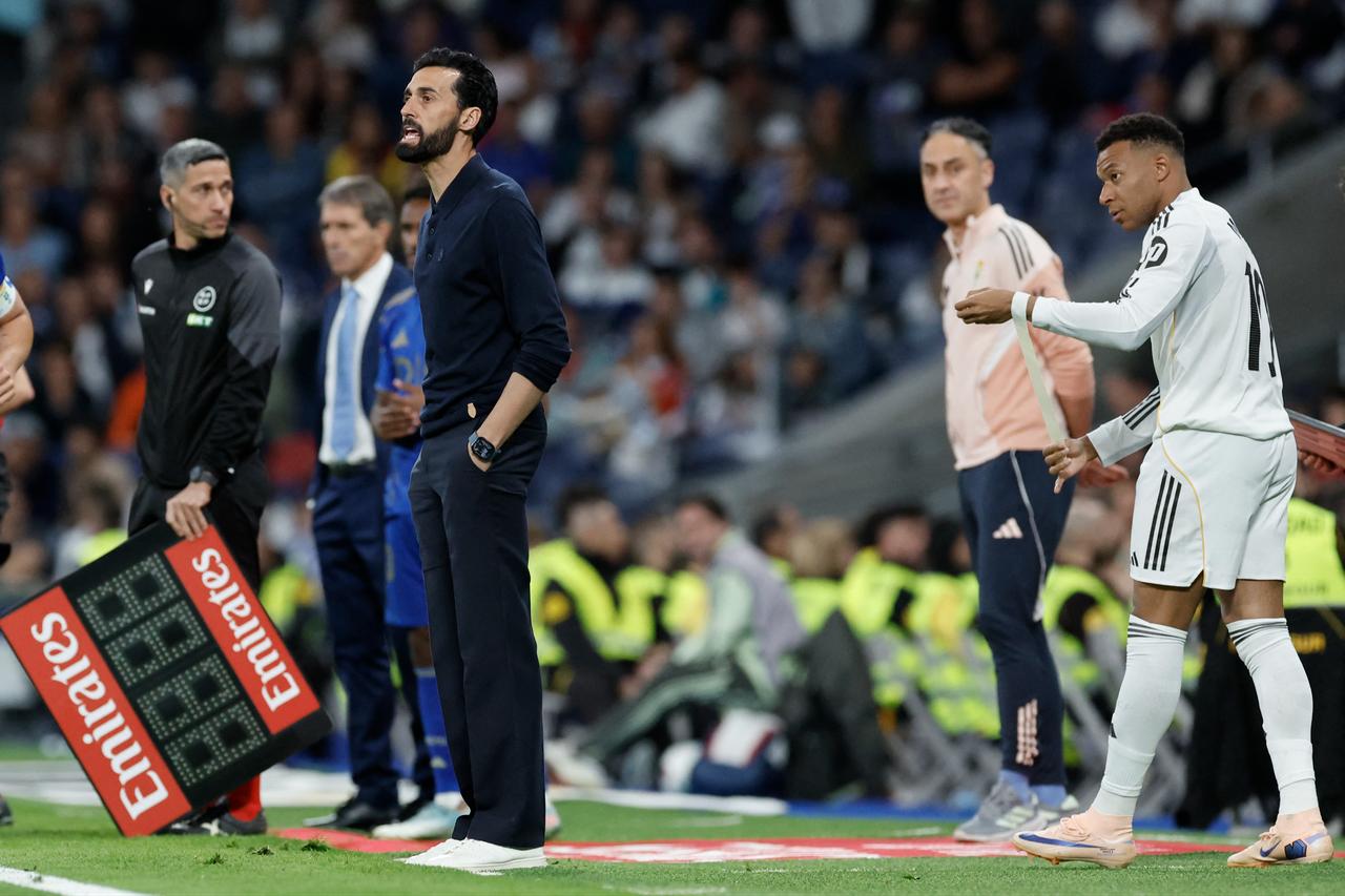 Real Madrid's French forward #10 Kylian Mbappe prepares himself to take to the field next to Real Madrid's Spanish coach Alvaro Arbeloa (L) during the Spanish league football match between Real Madrid CF and Real Oviedo at Santiago Bernabeu Stadium in Madrid, Spain, May 14, 2026. (AFP Photo)