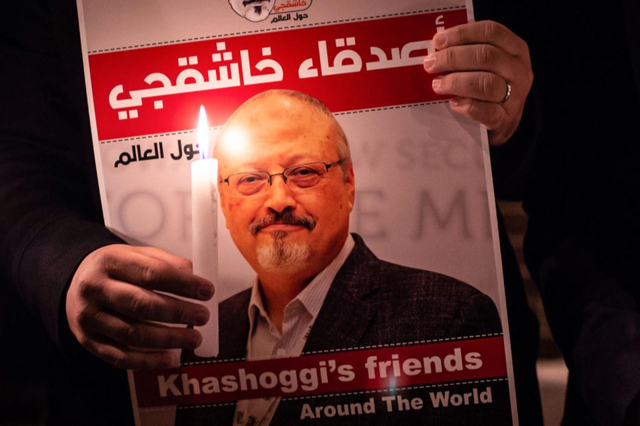 A demonstrator holds a poster picturing Saudi journalist Jamal Khashoggi and a lightened candle during a gathering outside the Saudi Arabia consulate in Istanbul, Oct. 25, 2018. (AFP Photo)