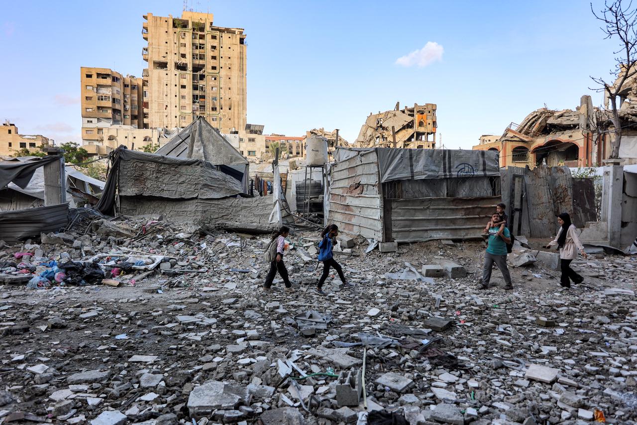 People walk outside a residential building that was hit by an Israeli strike the previous day in the Rimal neighbourhood of Gaza City, May 16, 2026. (AFP Photo)