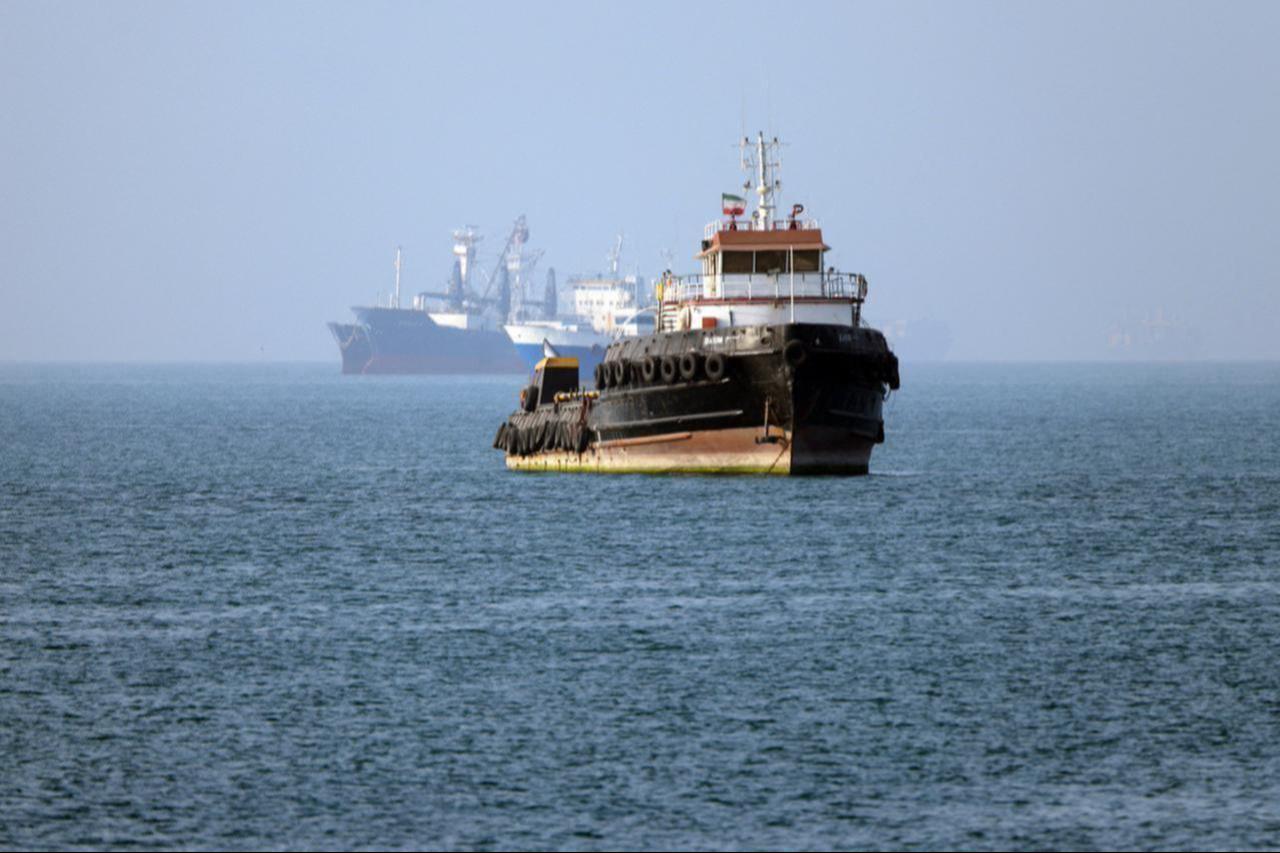 In this picture obtained from Iran's ISNA news agency on May 4, 2026, the Iran-flagged tugboat Basim sails near a ship anchored in the Strait of Hormuz off Bandar Abbas in southern Iran. (AFP Photo)