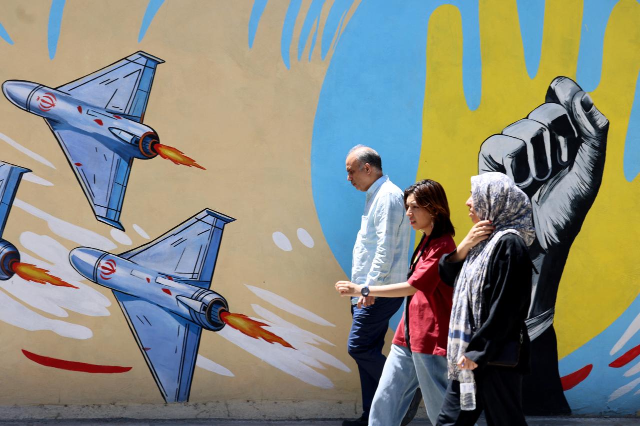 Iranians walk past an anti-US and anti-Israel mural painted on a wall in the capital Tehran on May 10, 2026. (AFP Photo)