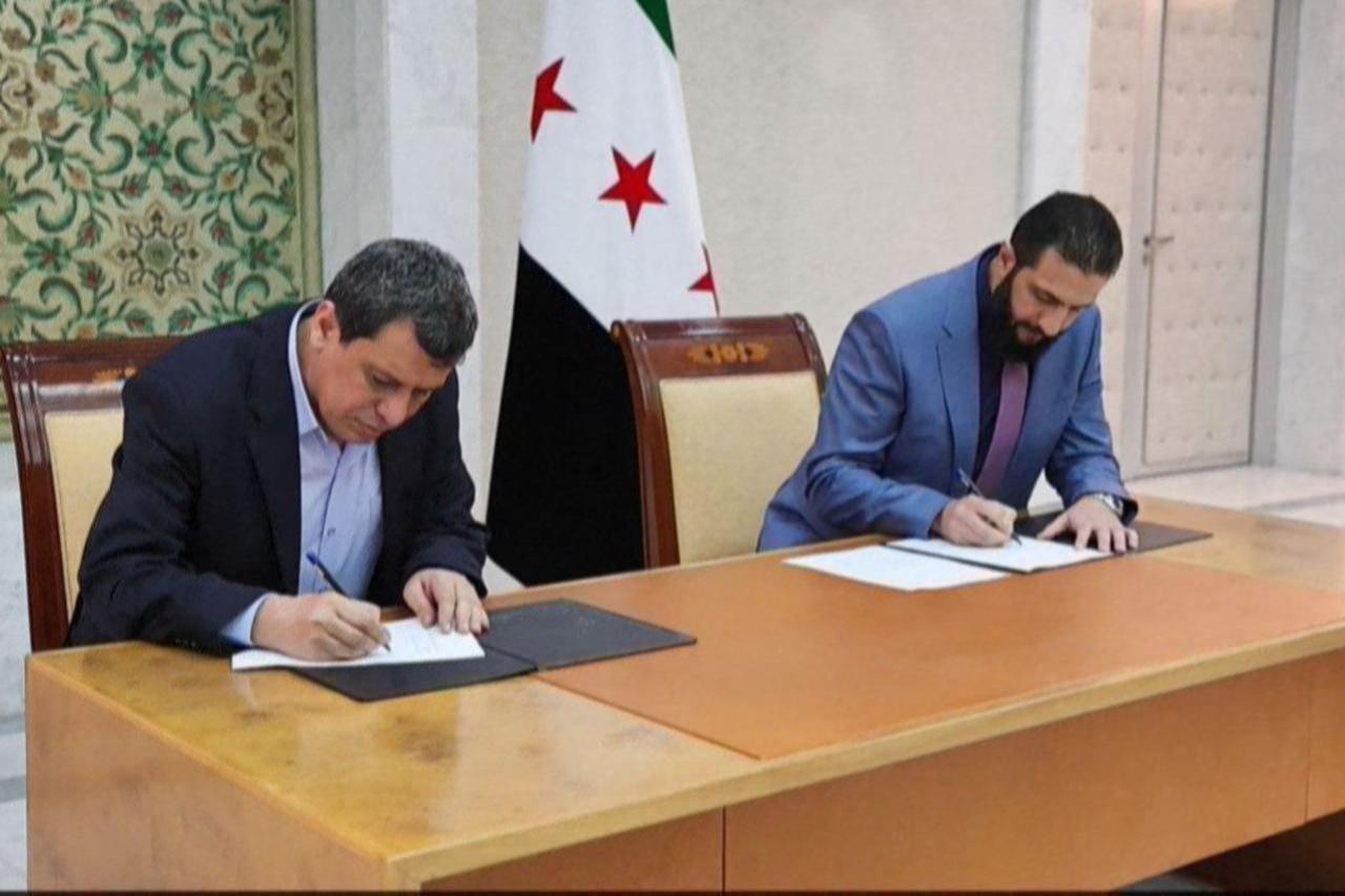 A SANA handout photo shows Syrian President Ahmed al-Sharaa and Mazloum Abdi, signing a deal to fold the Kurdish administration’s institutions into the national government in Damascus, Syria on March 10, 2025. (AFP Photo)