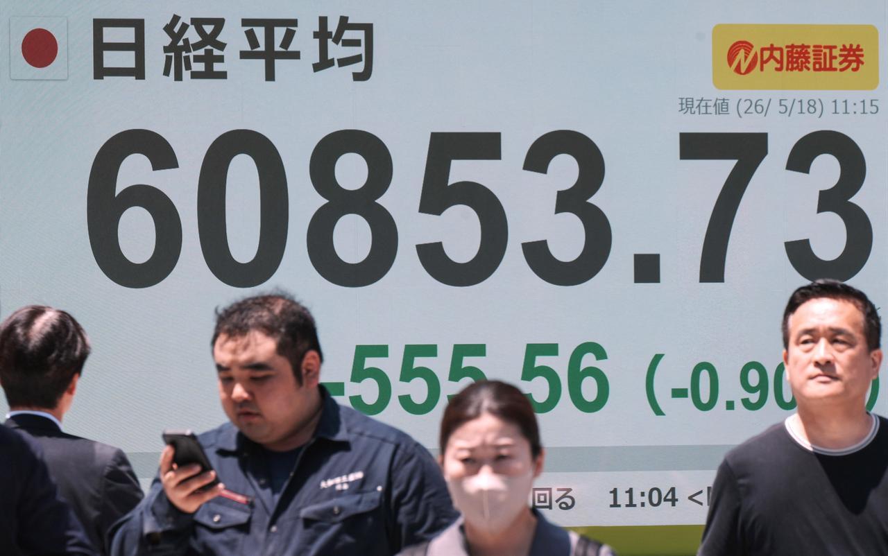 Pedestrians walk past an electronic quotation board displaying the Nikkei Stock Average on the Tokyo Stock Exchange along a street in Tokyo, May 18, 2026. (AFP Photo)