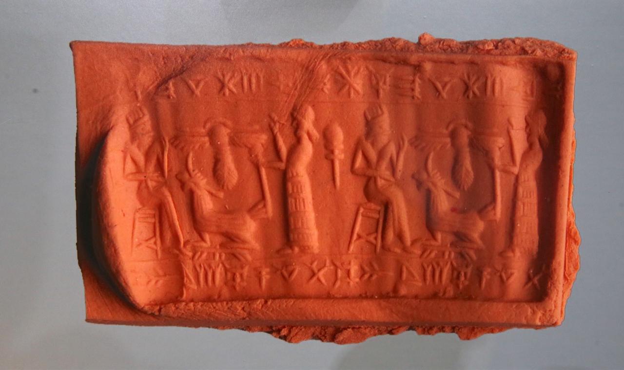 A photograph of a cylinder seal impression featuring ancient figures and symbols is displayed as part of the exhibition at Erzurum Museum in eastern Türkiye. (AA Photo)