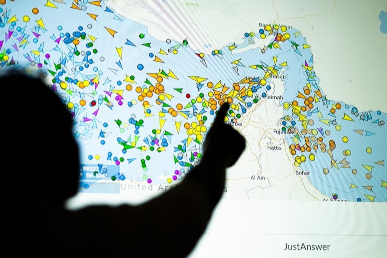 A photo illustration taken in Lefkosia on May 4, 2026, shows a person in front of a large screen displaying vessel movements in the Strait of Hormuz on a ship-tracking website. (AFP Photo)