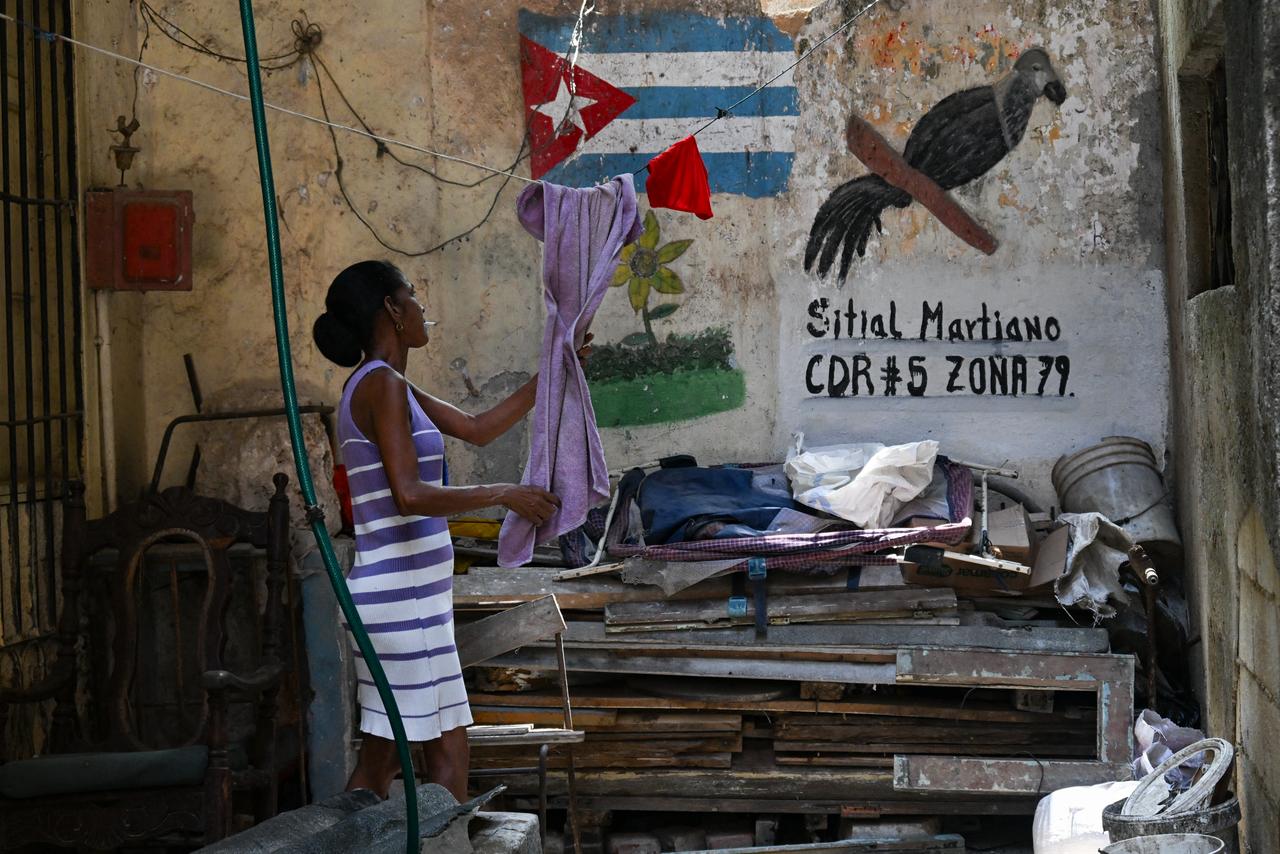 A woman takes a towel from her clothes line in a vacant lot in Havana on May 18, 2026. (AFP Photo)