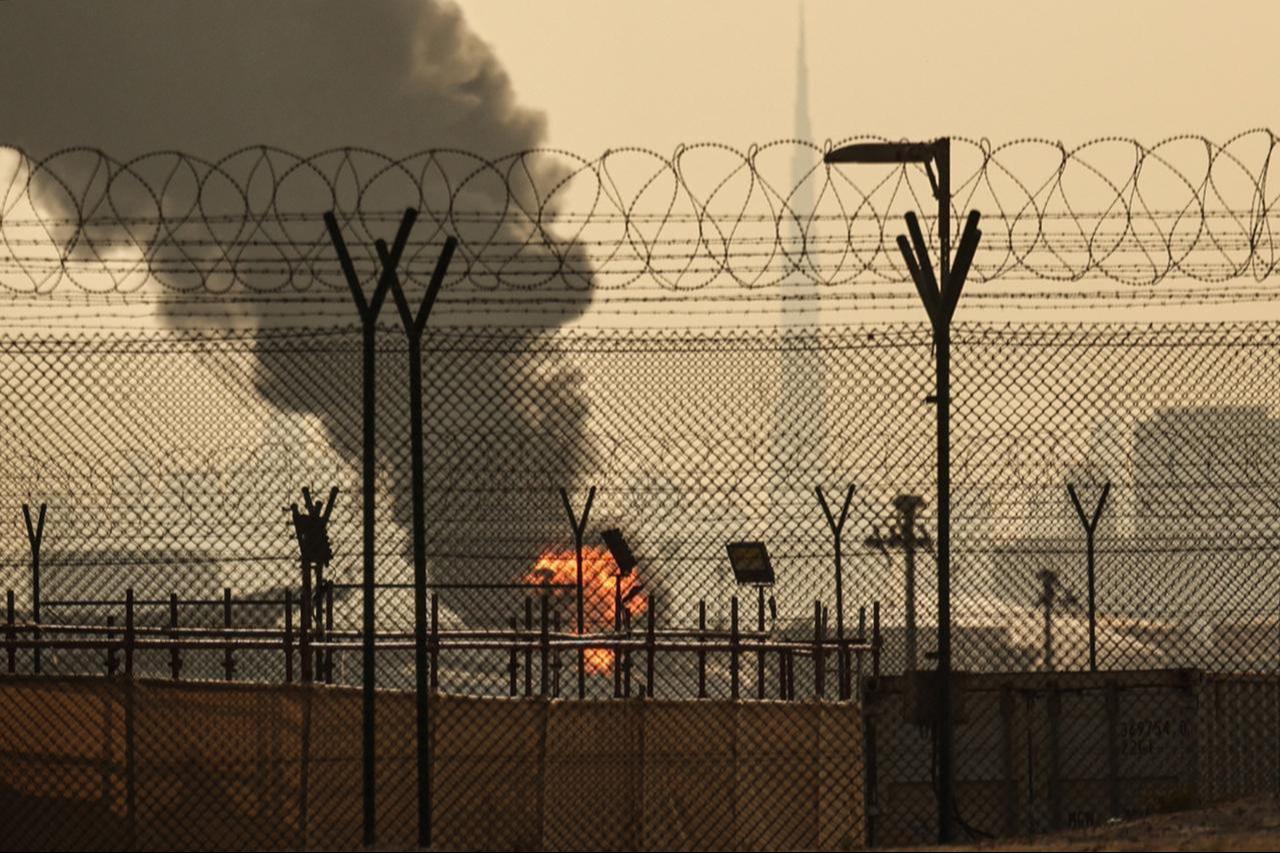 The Dubai skyline with the landmark Burj Khalifa skyscraper (R) is pictured as a smoke plume rises from an ongoing fire near Dubai International Airport, UAE on March 16, 2026. (AFP Photo)