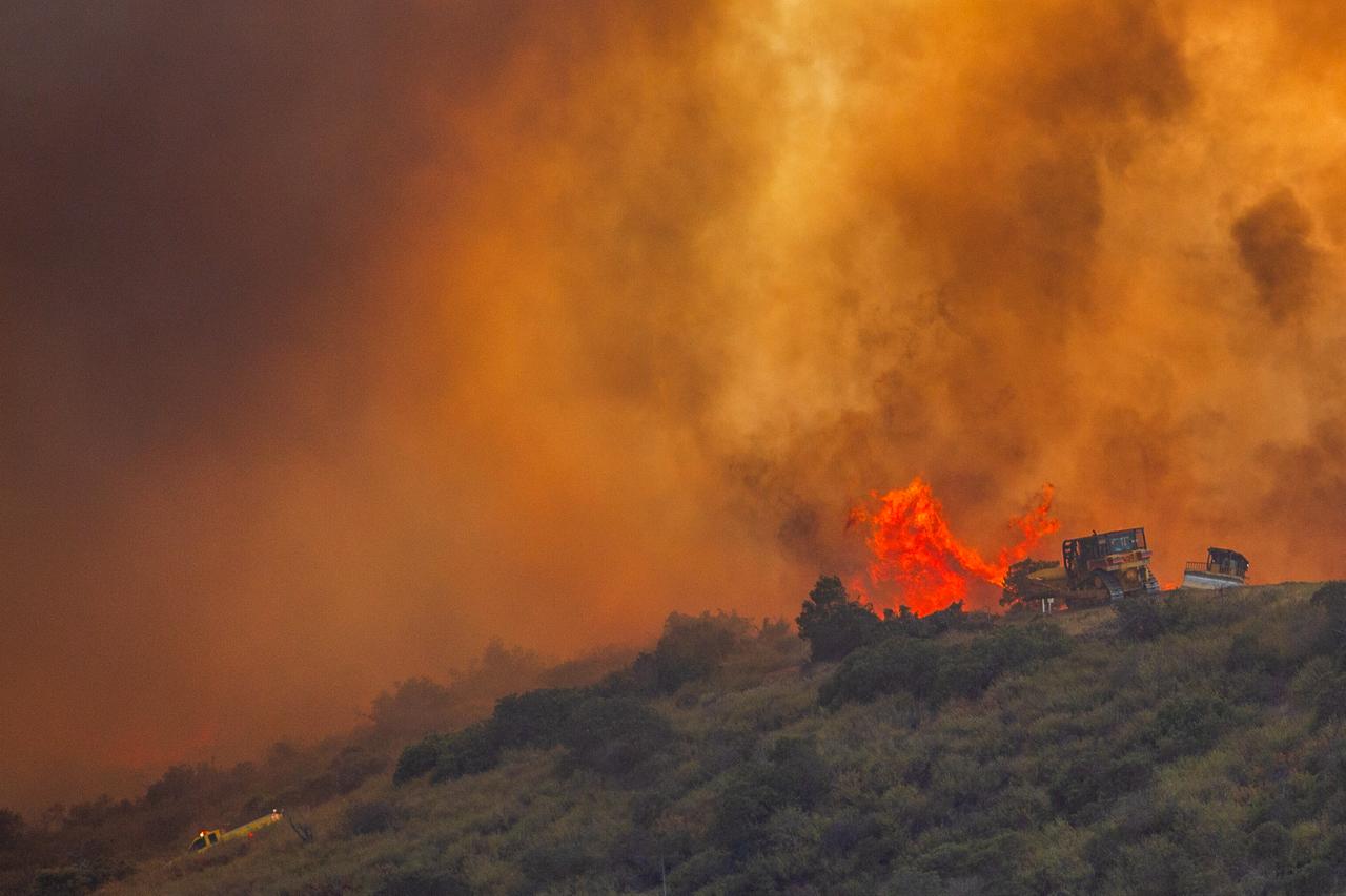 Fire fighters use a bulldozer to combat the Sandy Fire as it burns on a hill at a residential area in Simi Valley, California, on May 18, 2026. (AFP Photo)