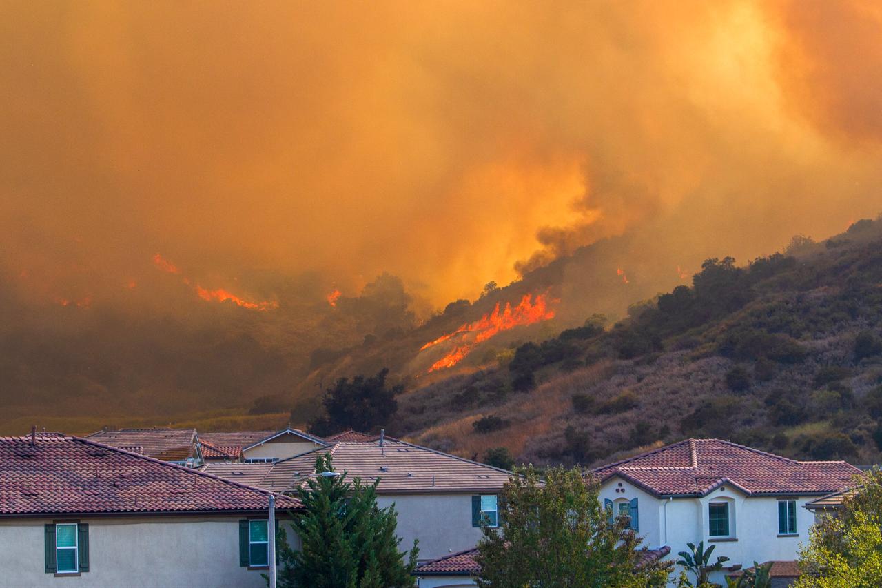 The Sandy Fire rages on a hill behind houses at a residential area in Simi Valley, California, on May 18, 2026. (AFP Photo)