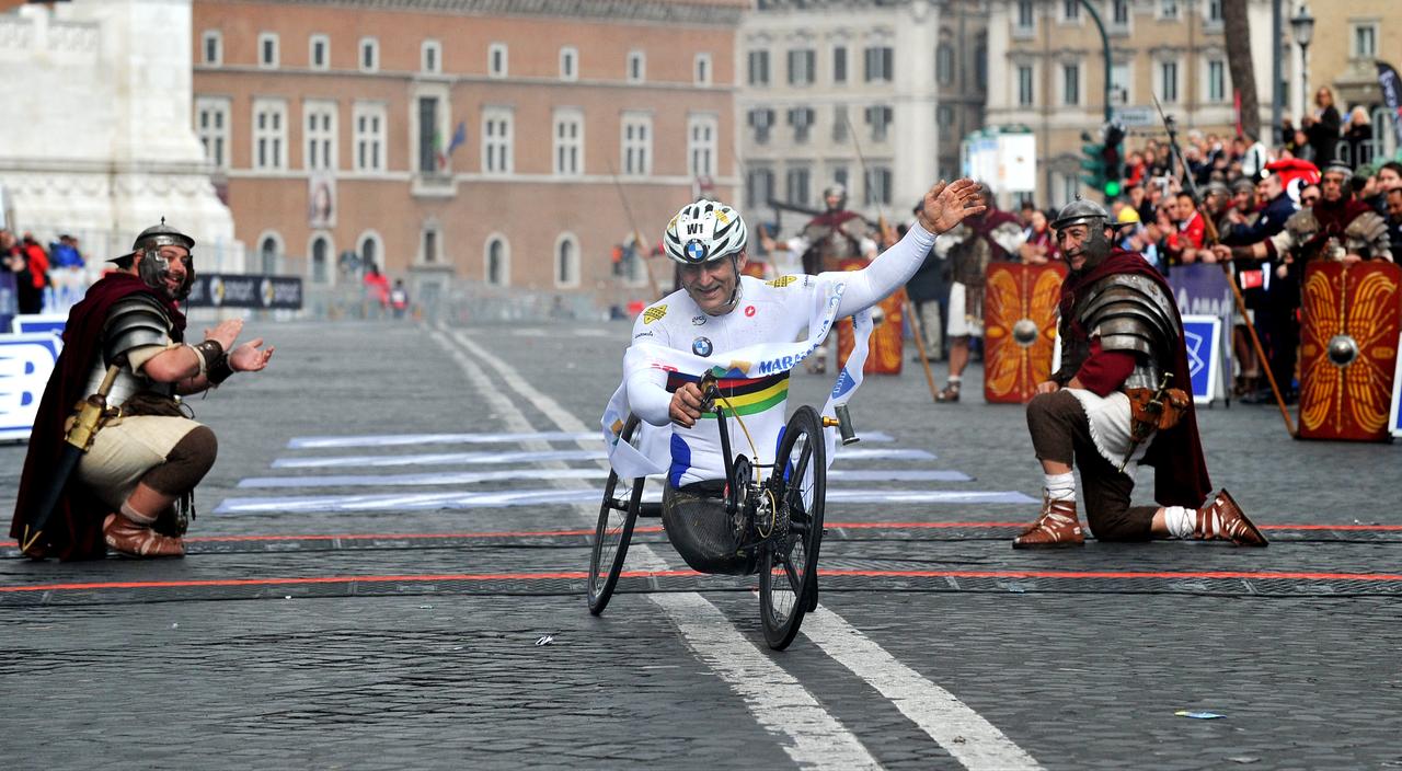 Former driver and paracyclist Alex Zanardi celebrates as he crosses the fininsh line of the 20th Marathon of Rome on March 23, 2014. (AFP Photo)