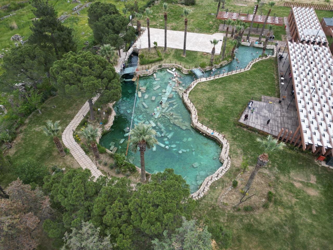 An aerial view shows visitors exploring the Cleopatra Pool, where historical remains lie beneath clear thermal waters in Pamukkale, Denizli, Türkiye. (AA Photo)