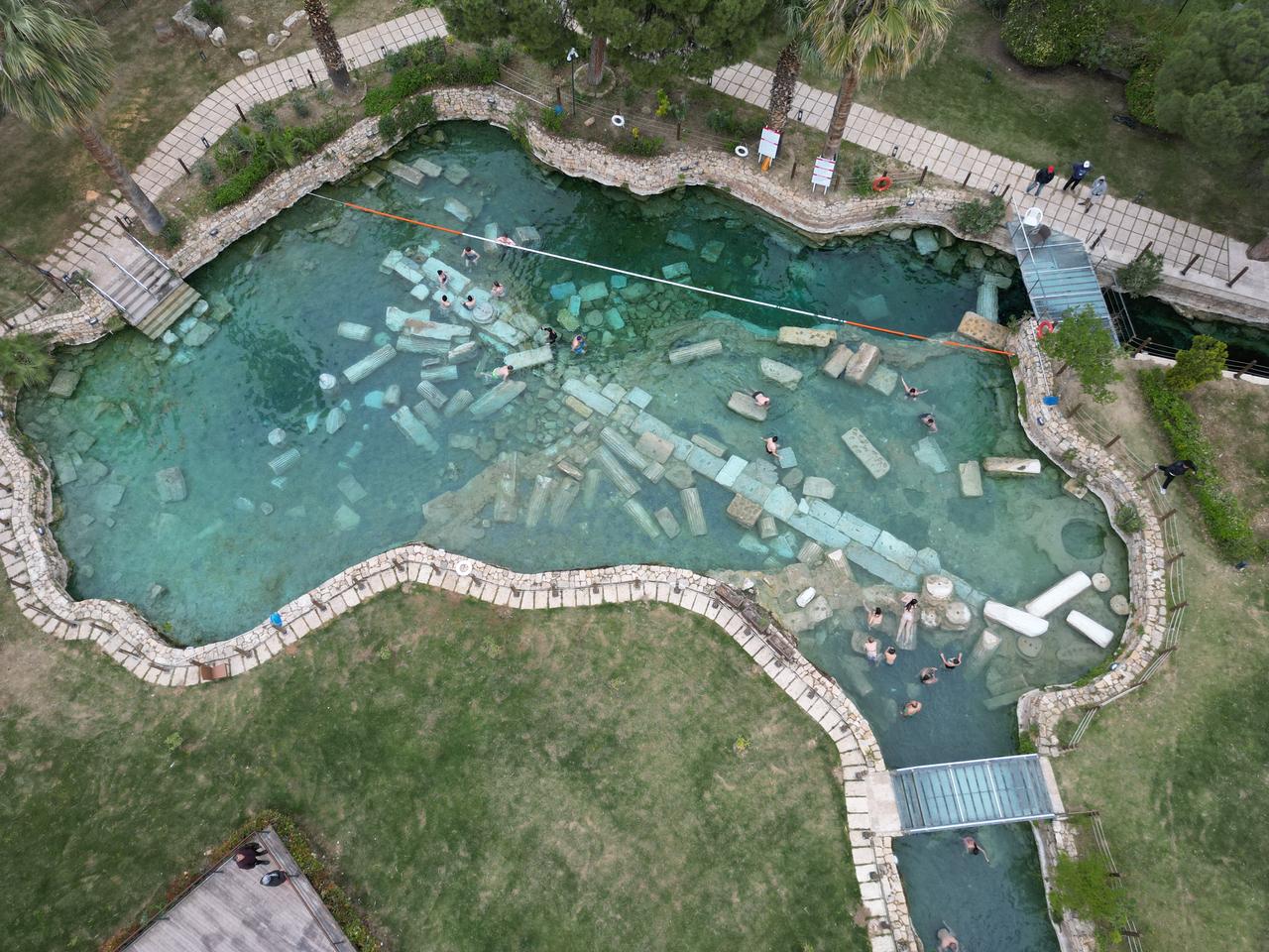 An aerial view shows visitors exploring the Cleopatra Pool, where historical remains lie beneath clear thermal waters in Pamukkale, Denizli, Türkiye. (AA Photo)