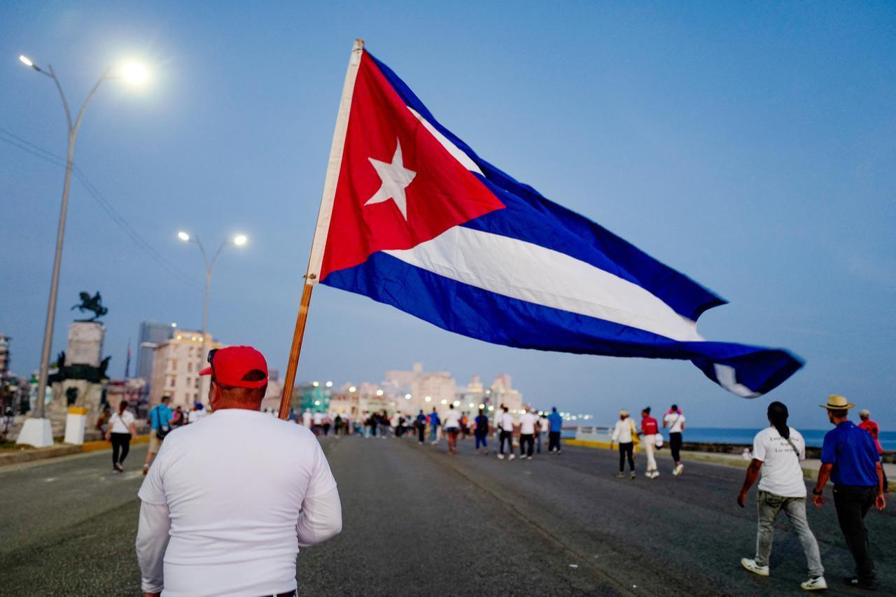 A man marches holding a Cuban national flag along Havana’s waterfront to mark International Workers’ Day in front of the US Embassy in Havana, May 1, 2026. (AFP Photo)
