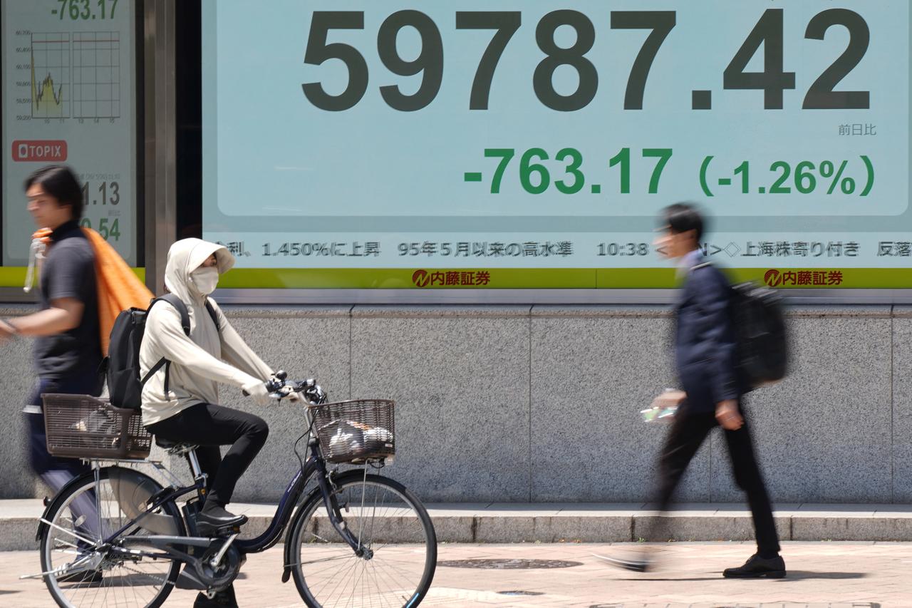 Passersby walk in front of an electronic quotation board displaying the Nikkei Stock Average on the Tokyo Stock Exchange along a street in Tokyo, May 20, 2026. (AFP Photo)