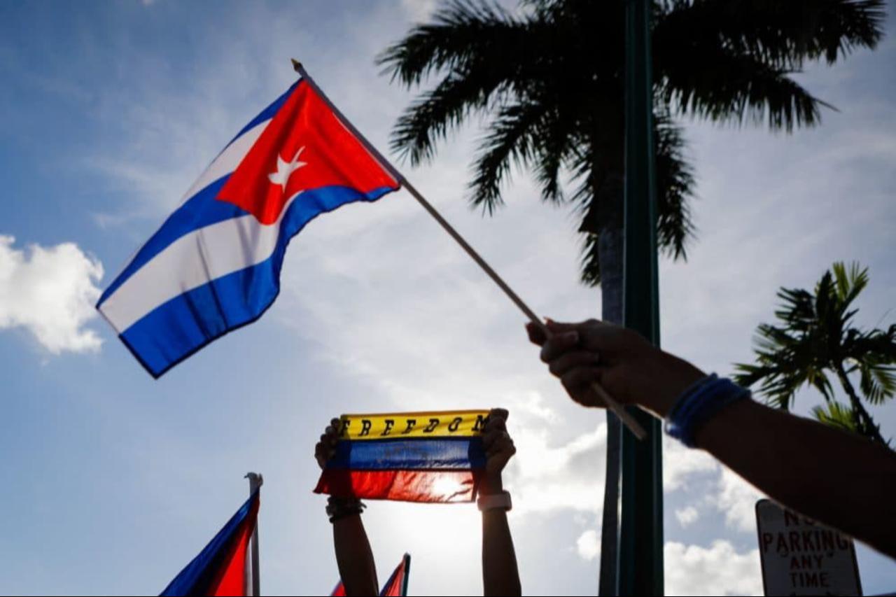A Cuban and a Venezuelan flag are seen during a protest in support of Cubans demonstrating against their government at Versailles Restaurant in Miami on July 18 2021. (AFP Photo)