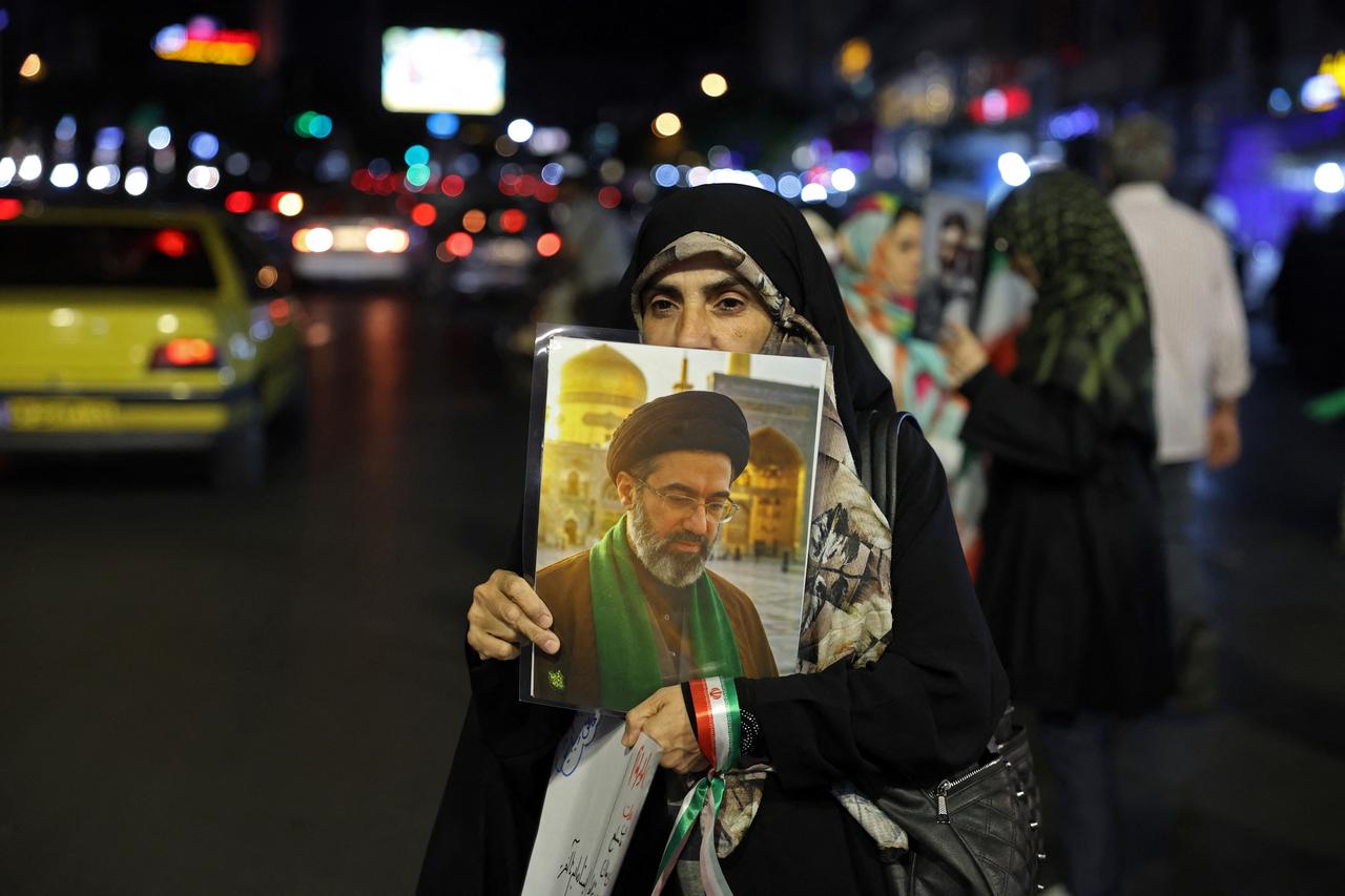 A woman holds a placard with photo of Iran's supreme leader Mojtaba Khamenei during an anti-US and Israel protest at the Hafte Tir Square in Tehran on May 17, 2026. (AFP Photo)